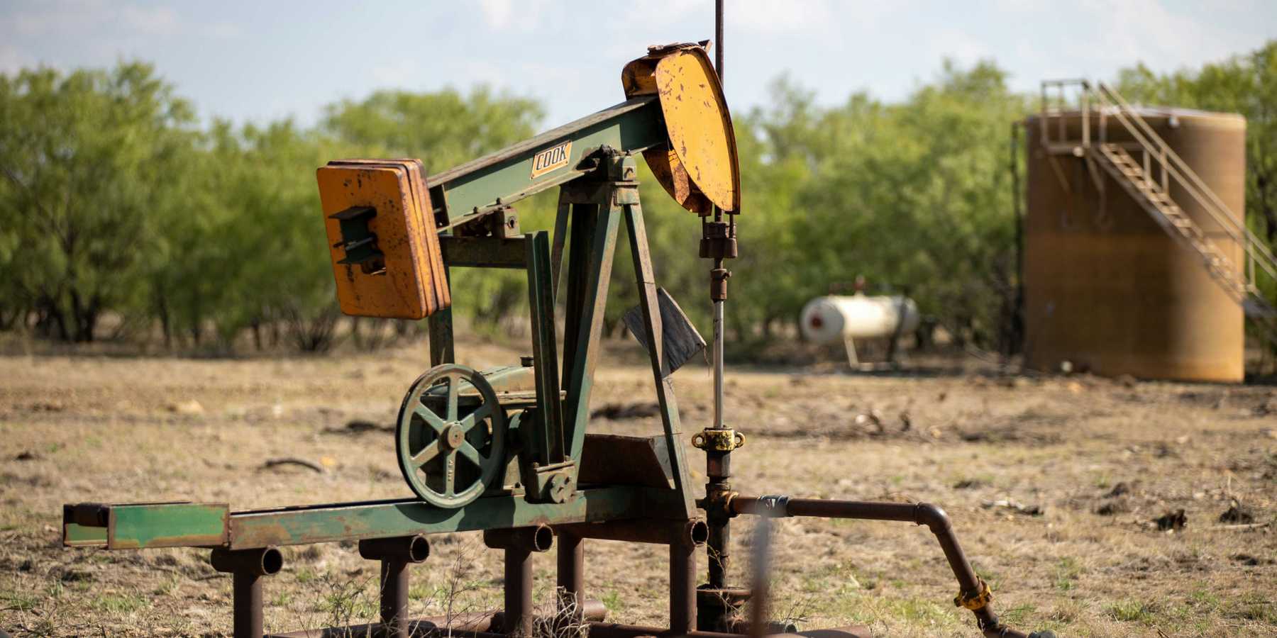An old oil well pump jack in a field.