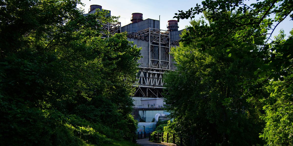 An old power plant framed by a green path.