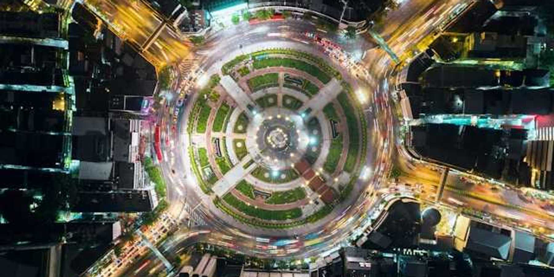 An overhead view of a city roundabout with a park in the middle