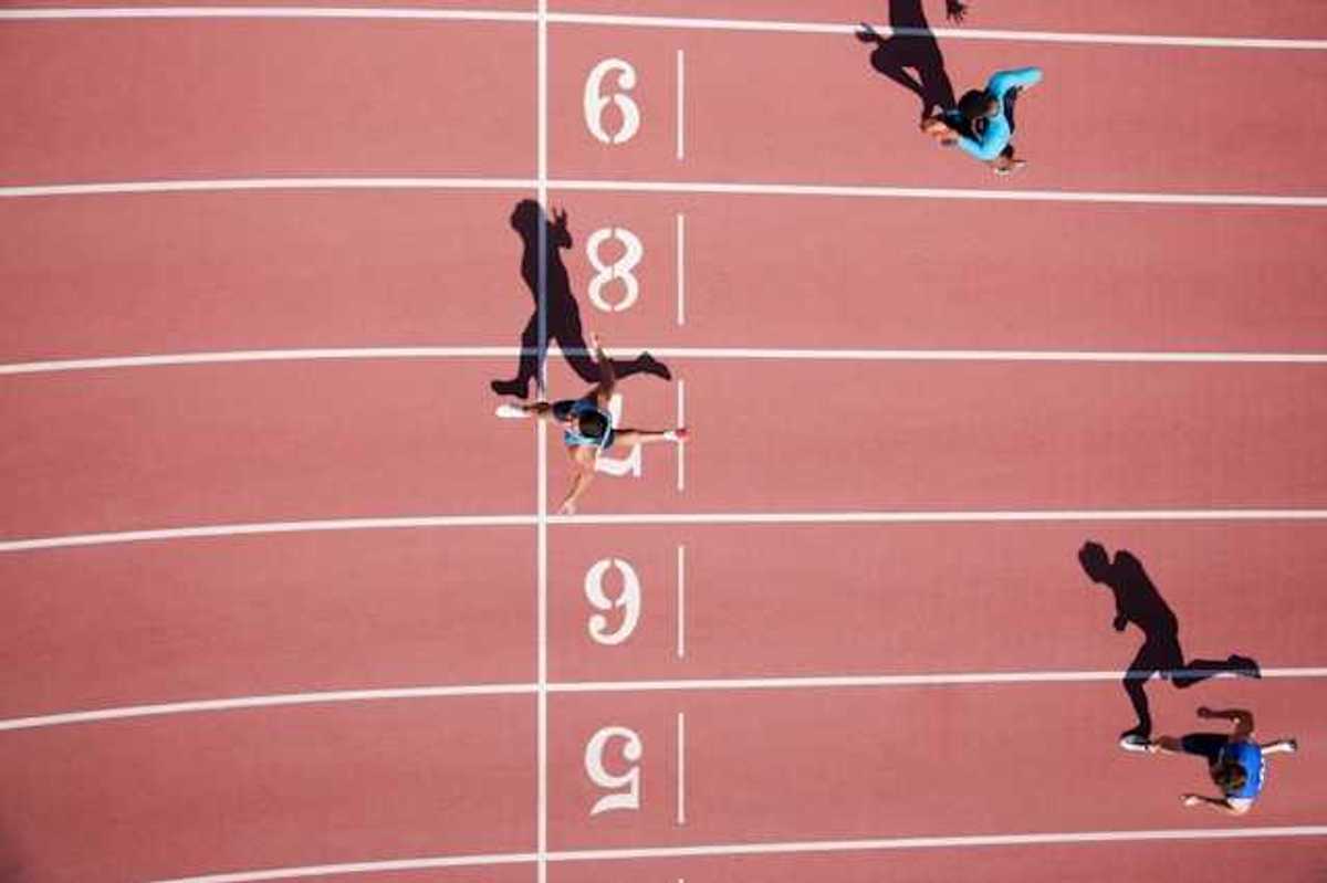An overhead view of a running track with runners crossing the finish line