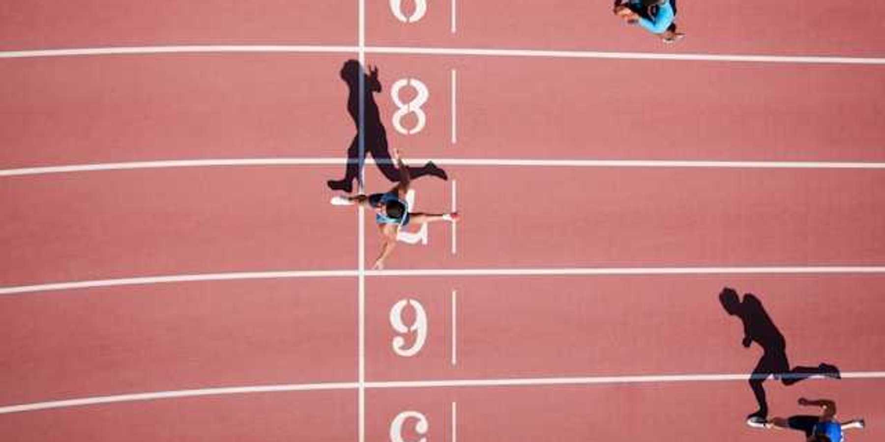 An overhead view of a running track with runners crossing the finish line
