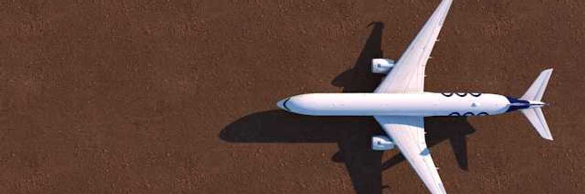 An overhead view of a white airplane on a brown tarmac