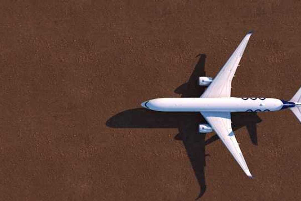 An overhead view of a white airplane on a brown tarmac