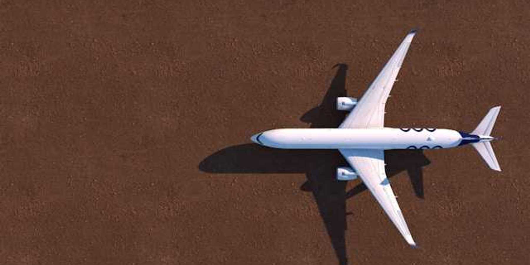 An overhead view of a white airplane on a brown tarmac