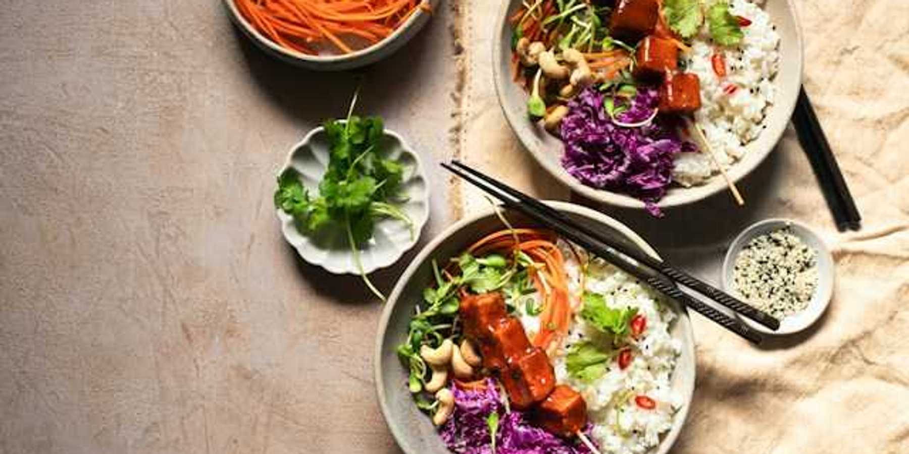 An overhead view of two rice and tofu bowls