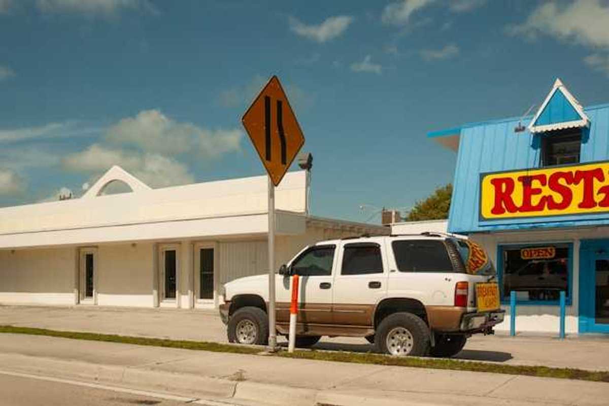 An SUV parked in front of a restaurant on a sunny day
