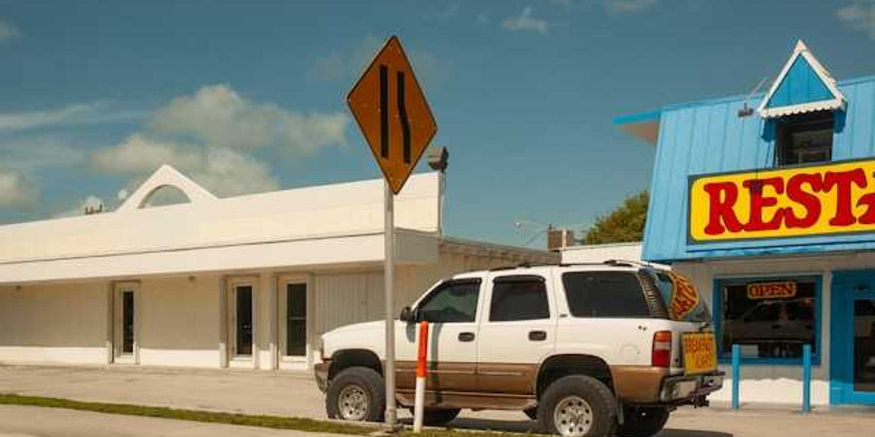 An SUV parked in front of a restaurant on a sunny day