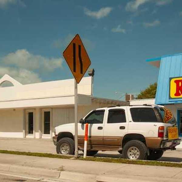An SUV parked in front of a restaurant on a sunny day