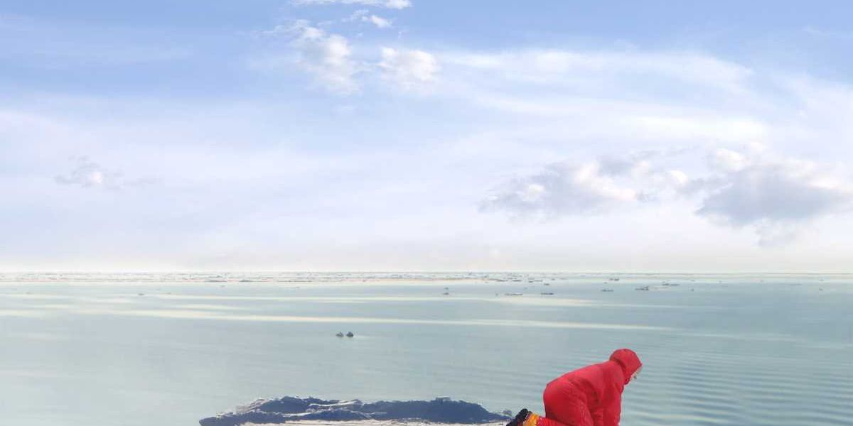 Arctic  scientist in red parka stranded on an ice floe.