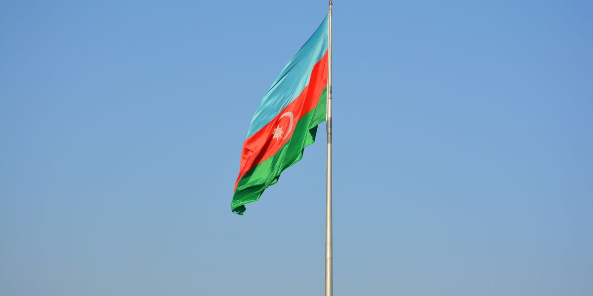 Azerbaijan flag flying in the wind on top of a flag pole