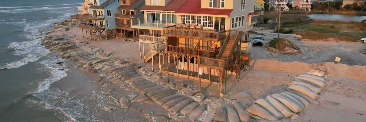Beach homes, partially protected by sand bags, at the edge of North Topsail Island in North Carolina coast.