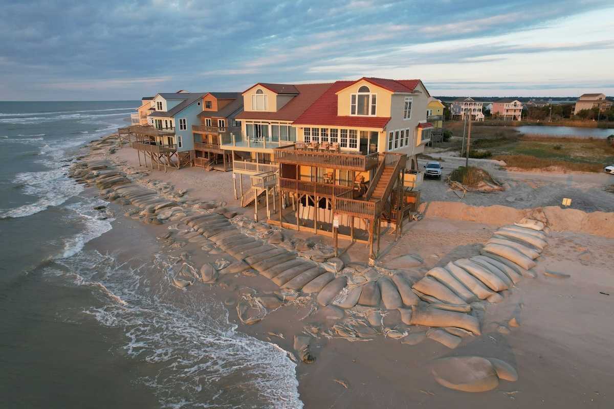 Beach homes, partially protected by sand bags, at the edge of North Topsail Island in North Carolina coast.