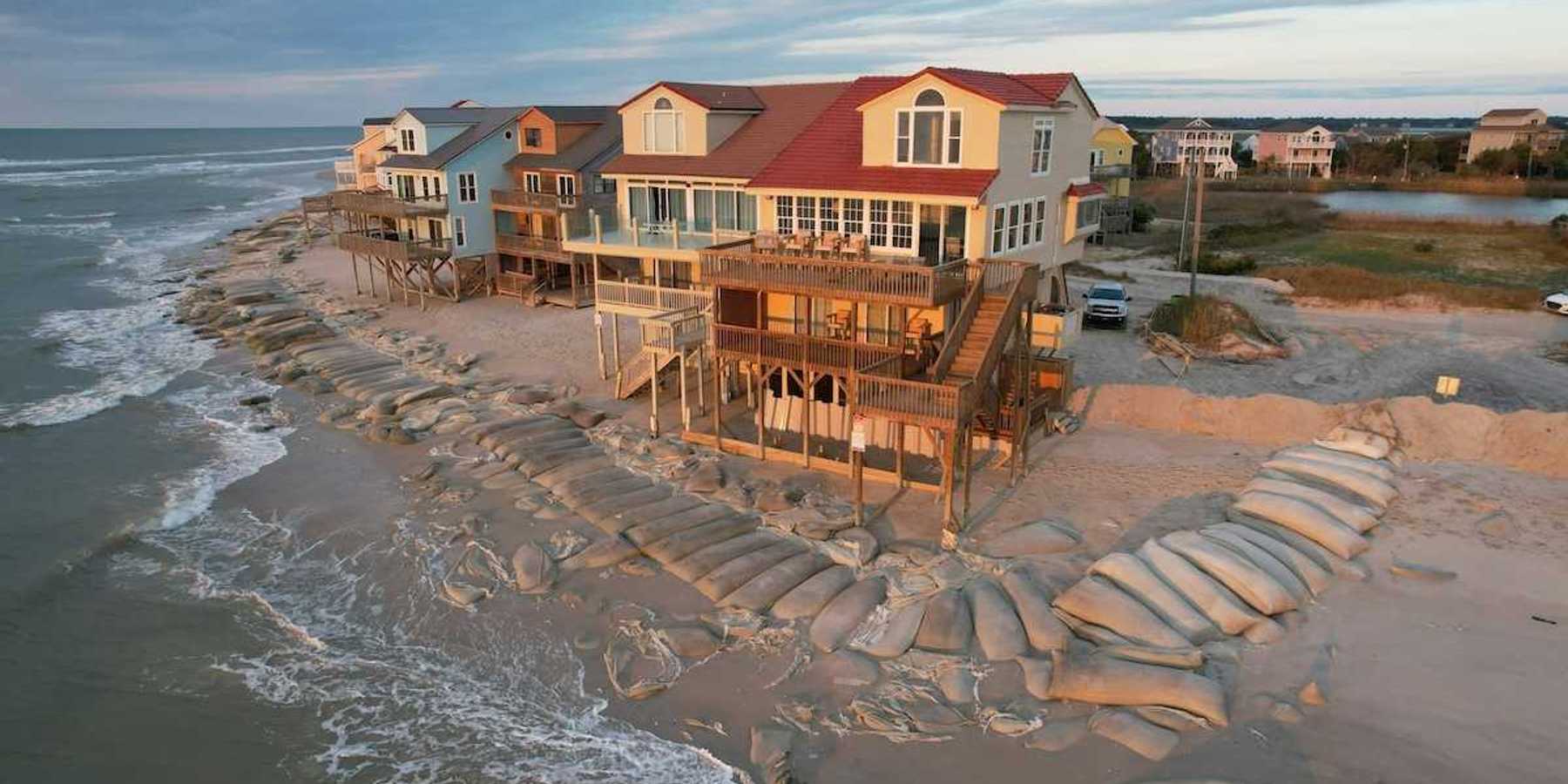 Beach homes, partially protected by sand bags, at the edge of North Topsail Island in North Carolina coast.