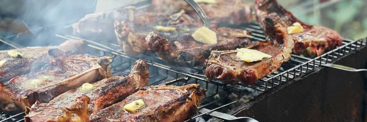 Beef with tabs of butter on an outdoor grill