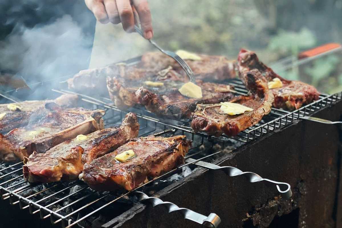 Beef with tabs of butter on an outdoor grill