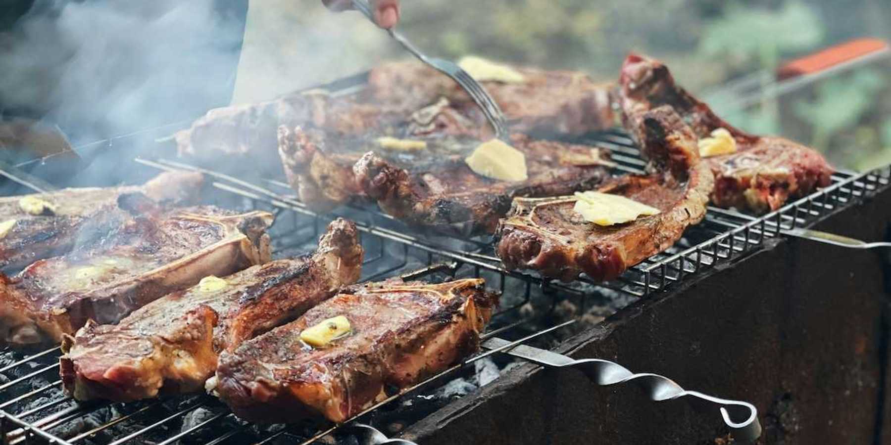 Beef with tabs of butter on an outdoor grill