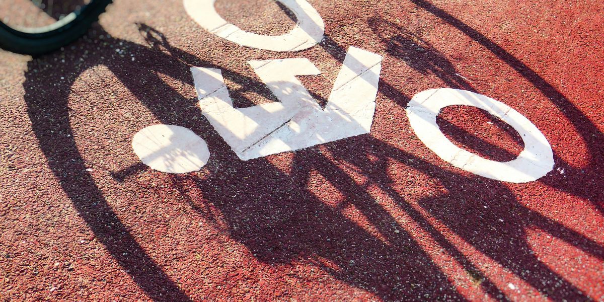 Bike lane logo on the pavement with the shadow of a bike on it.