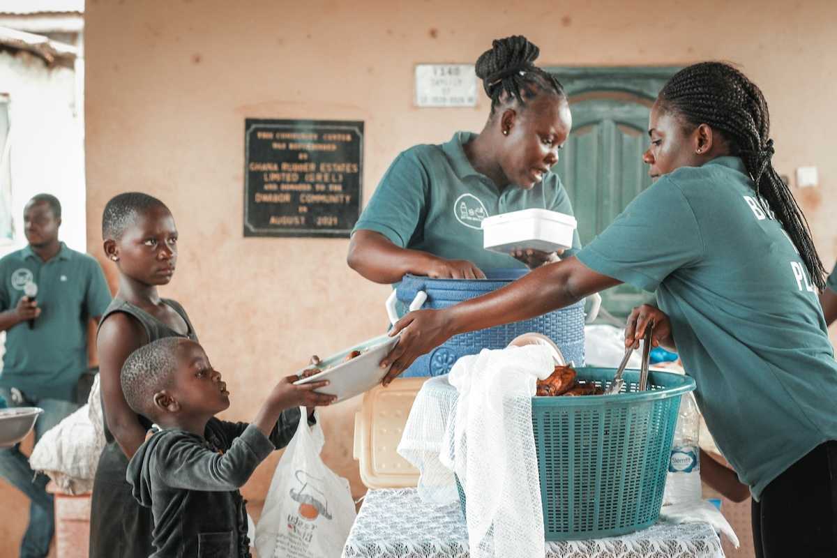 Black children being served at a food kitchen.