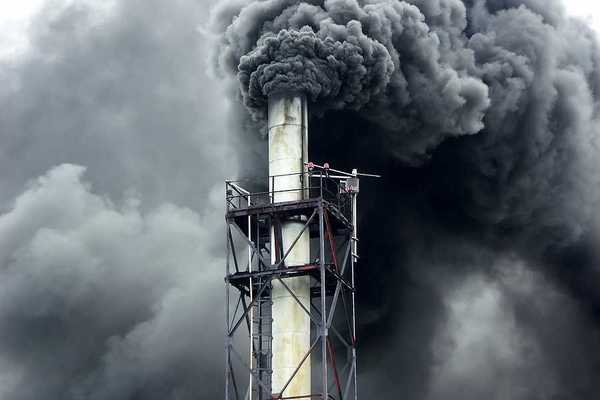 Black smoke billowing out of a smokestack
