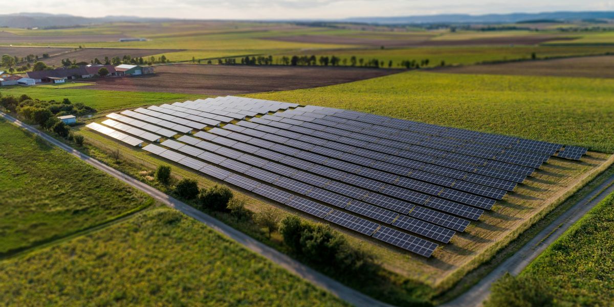 black solar panels on green grass field during daytime.