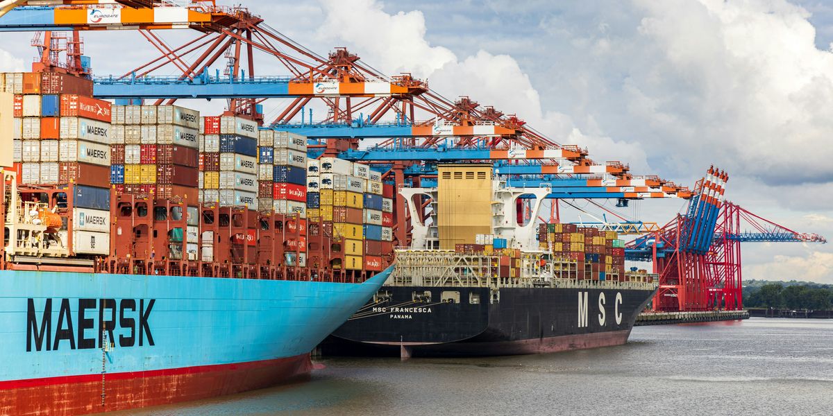 blue and red cargo ship on dock during daytime.