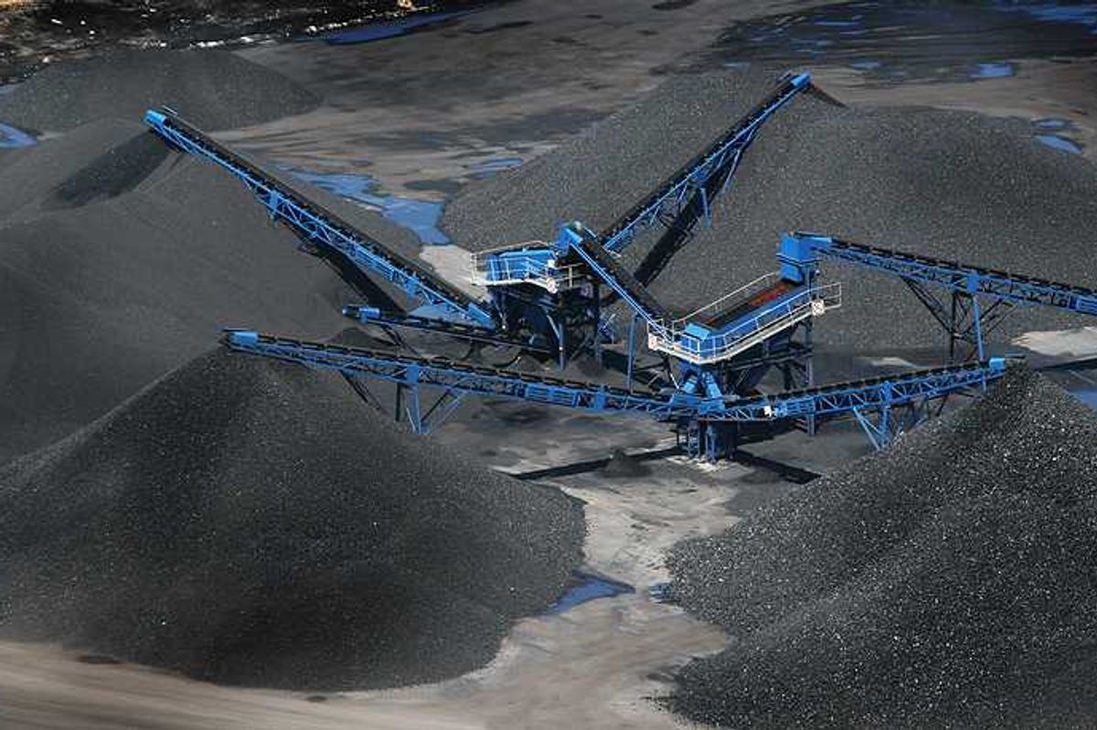 Blue cranes placing coal onto large piles