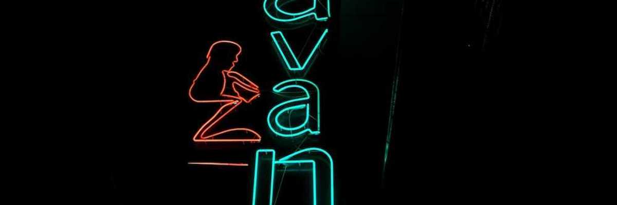 Blue-green neon sign on black background reads "Havana"
