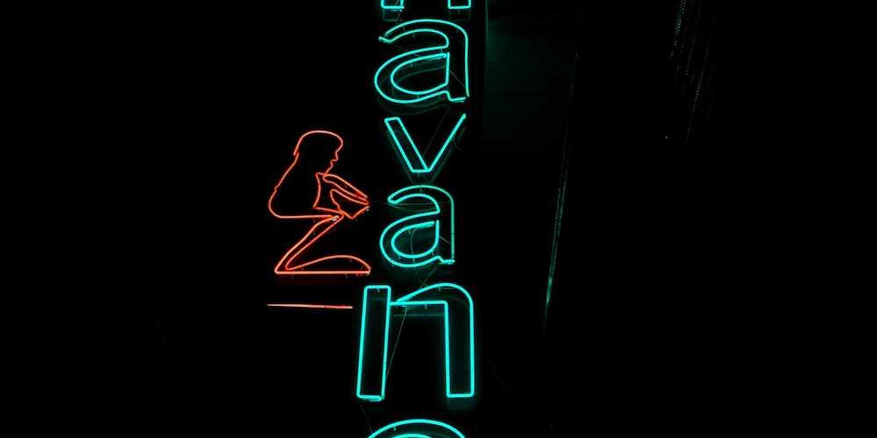 Blue-green neon sign on black background reads "Havana"