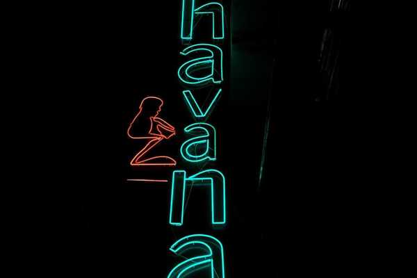 Blue-green neon sign on black background reads "Havana"