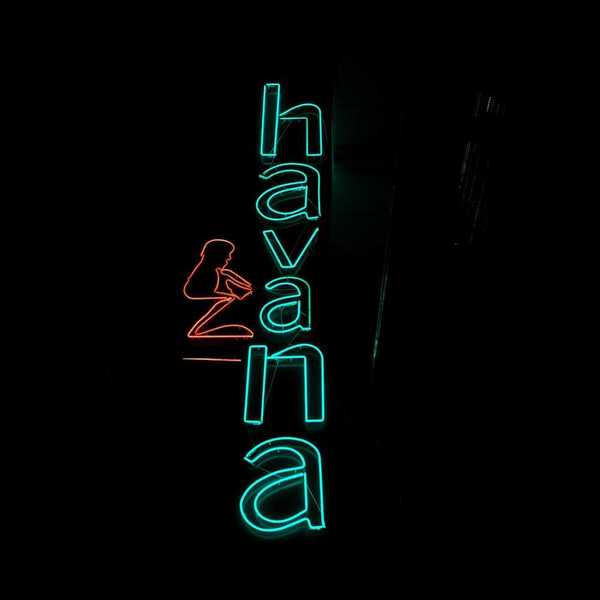 Blue-green neon sign on black background reads "Havana"