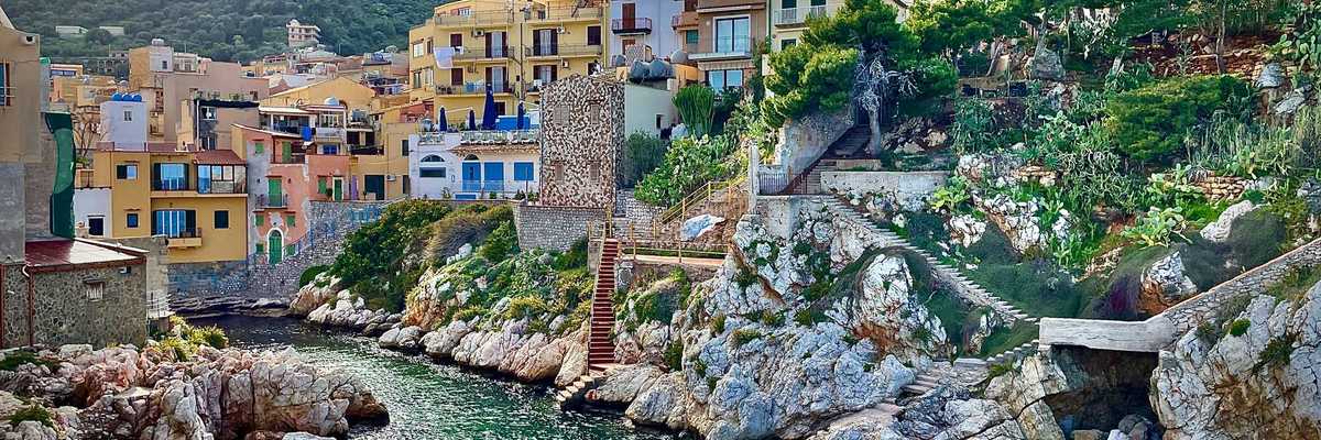 Blue-green sea water with a mediterranean village on the hills above the water