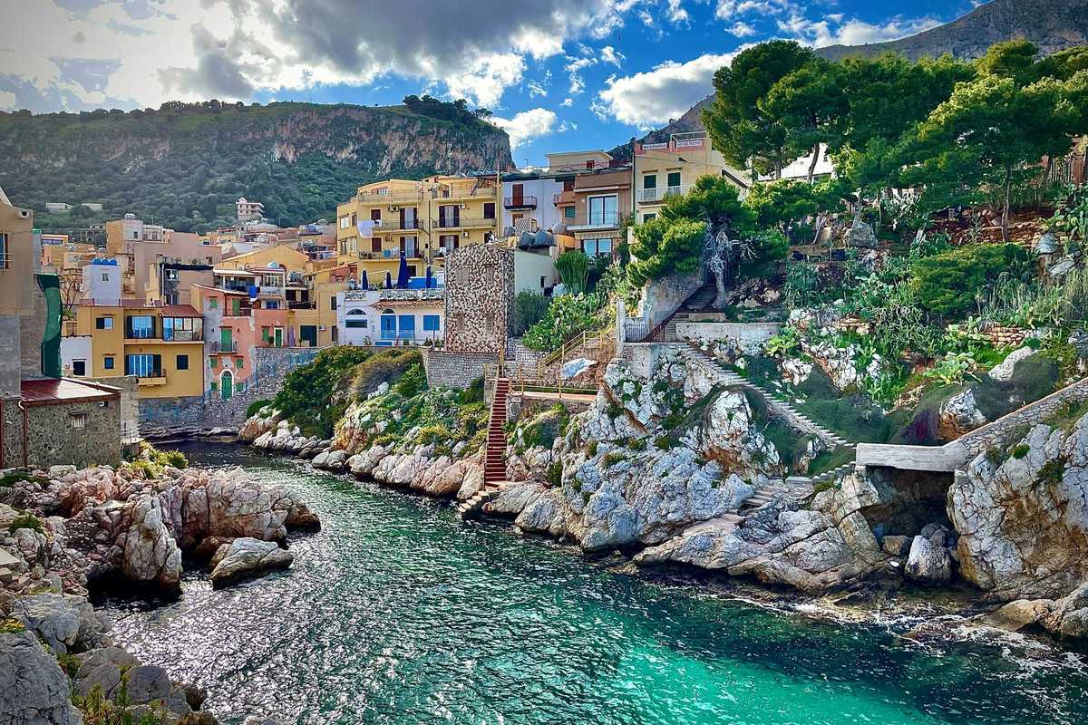 Blue-green sea water with a mediterranean village on the hills above the water