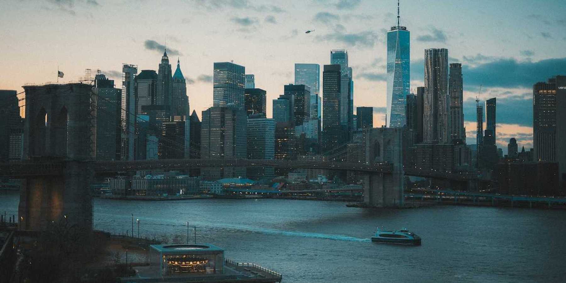 Boat traveling on a NYC waterway with Manhatten skyline in background
