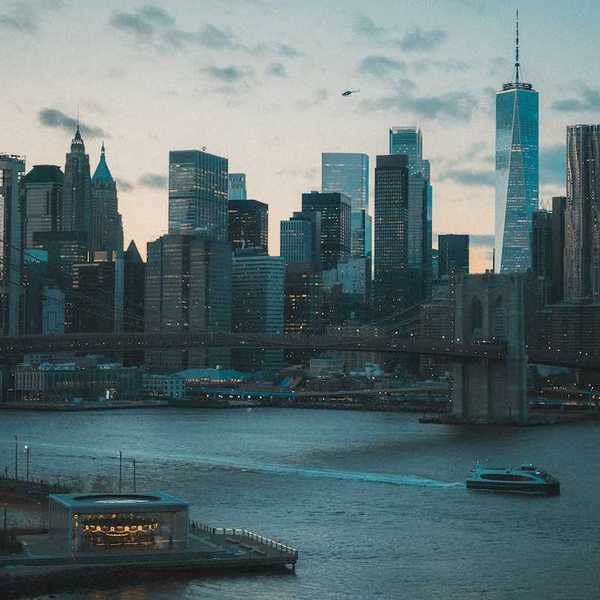Boat traveling on a NYC waterway with Manhatten skyline in background
