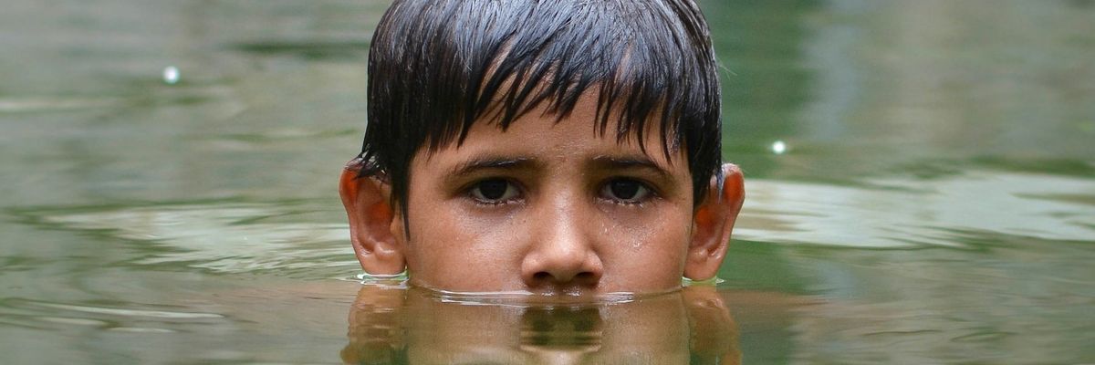 Boy immersed up to nose in floodwaters