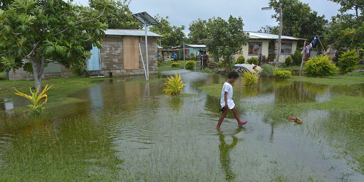 boy walking in floodwaters