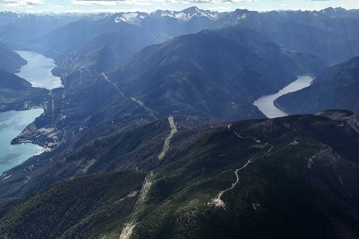 British Columbia landscape with hydro dam, powerlines and snowcapped Canadian Rockies