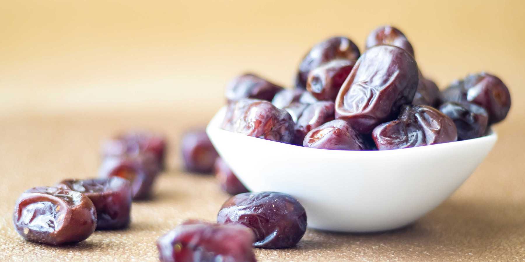 brown round fruit in white ceramic bowl
