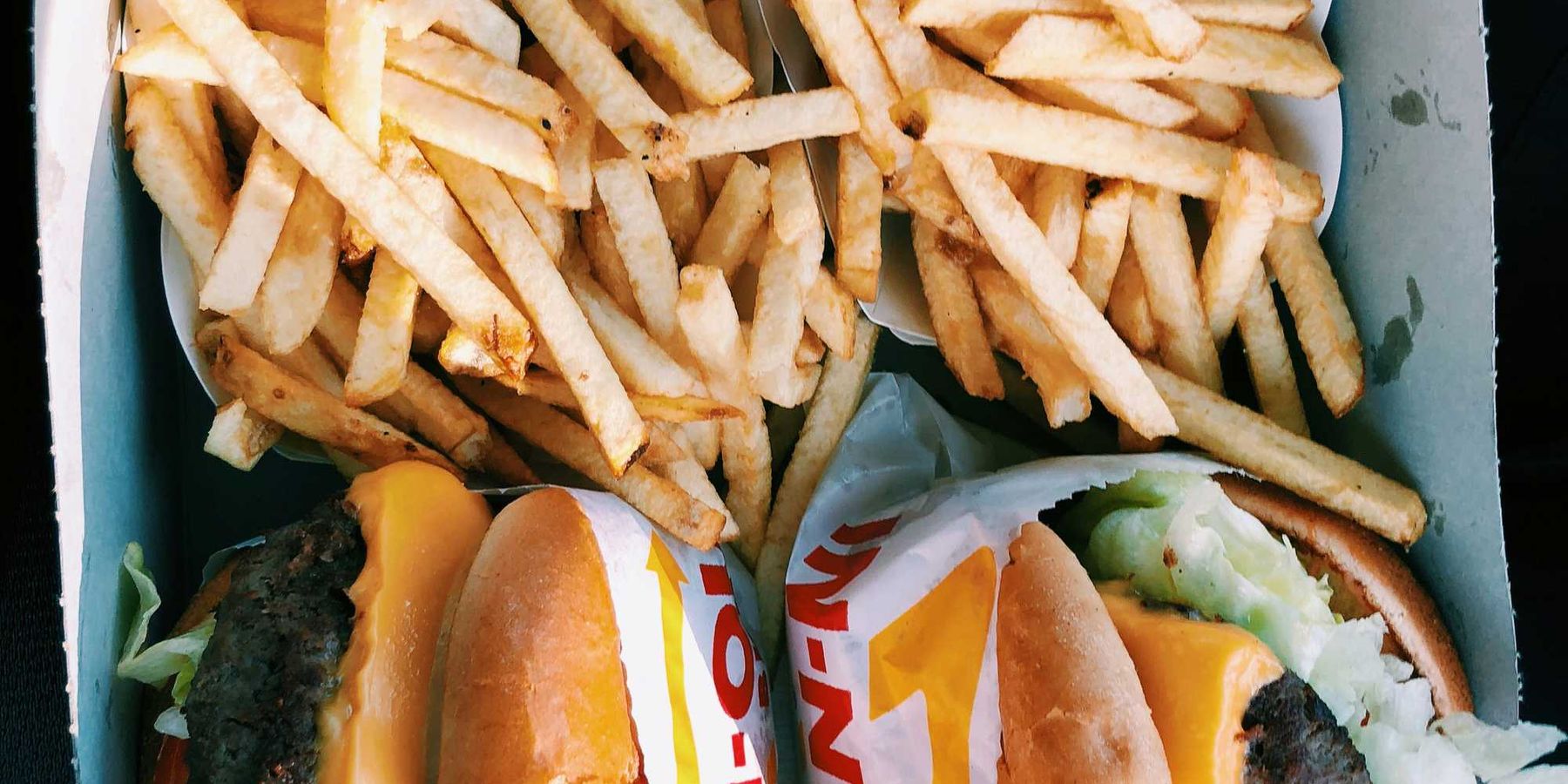 burgers and fries inside box.