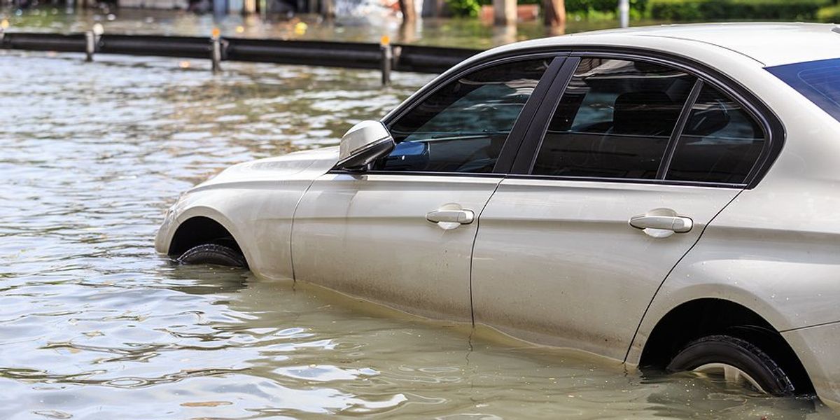 Car parked on a flooded street.