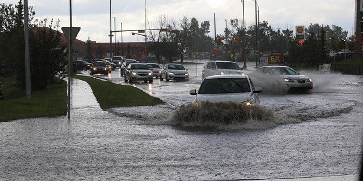 Cars driving through a flooded road.