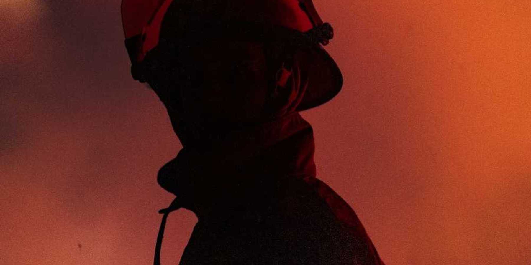 Chest-up view of firefighter in profile with mostly obscured face, faced towards the camera