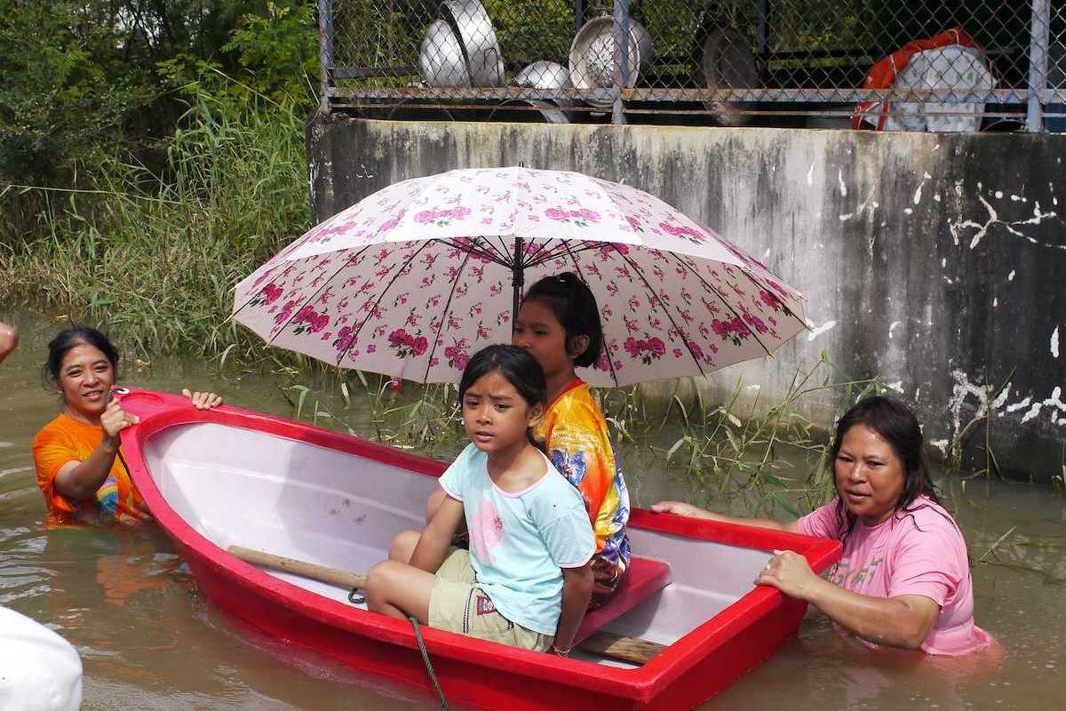 Children being transported through deep water in a small plastic dinghy during the monsoon flooding of October 24 2010 in Nakhon Ratchasima Thailand.