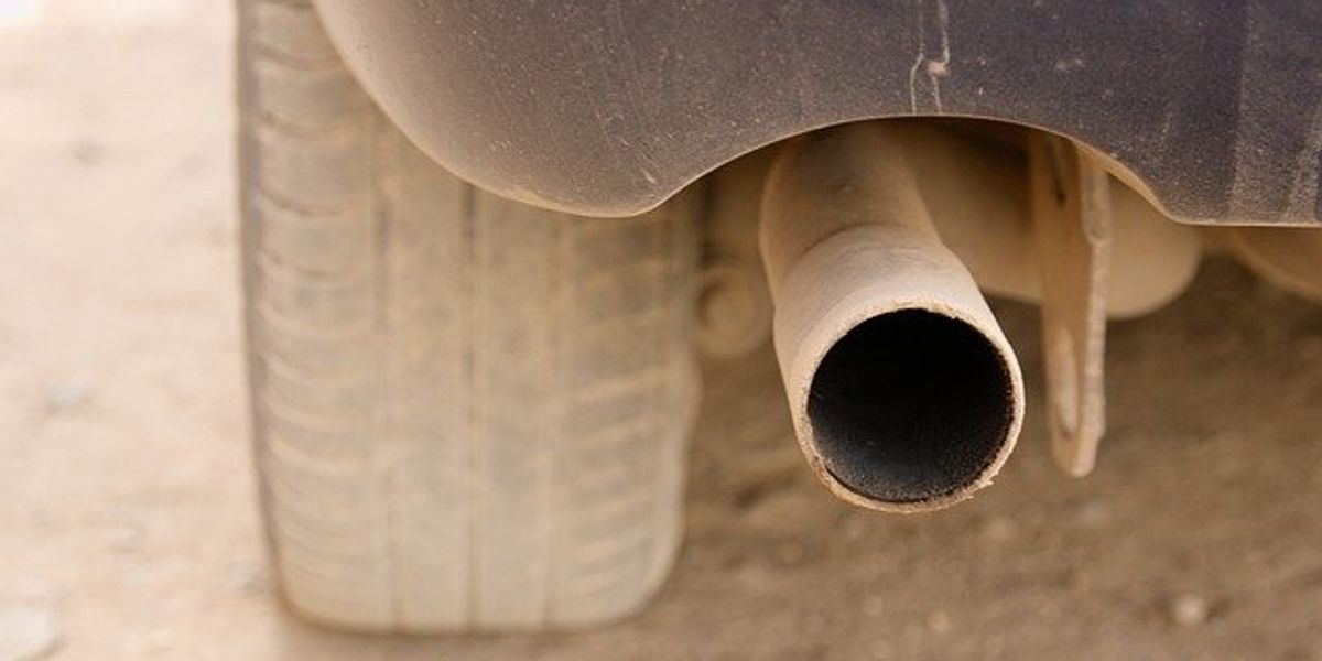 Closeup of tailpipe on a dusty car.