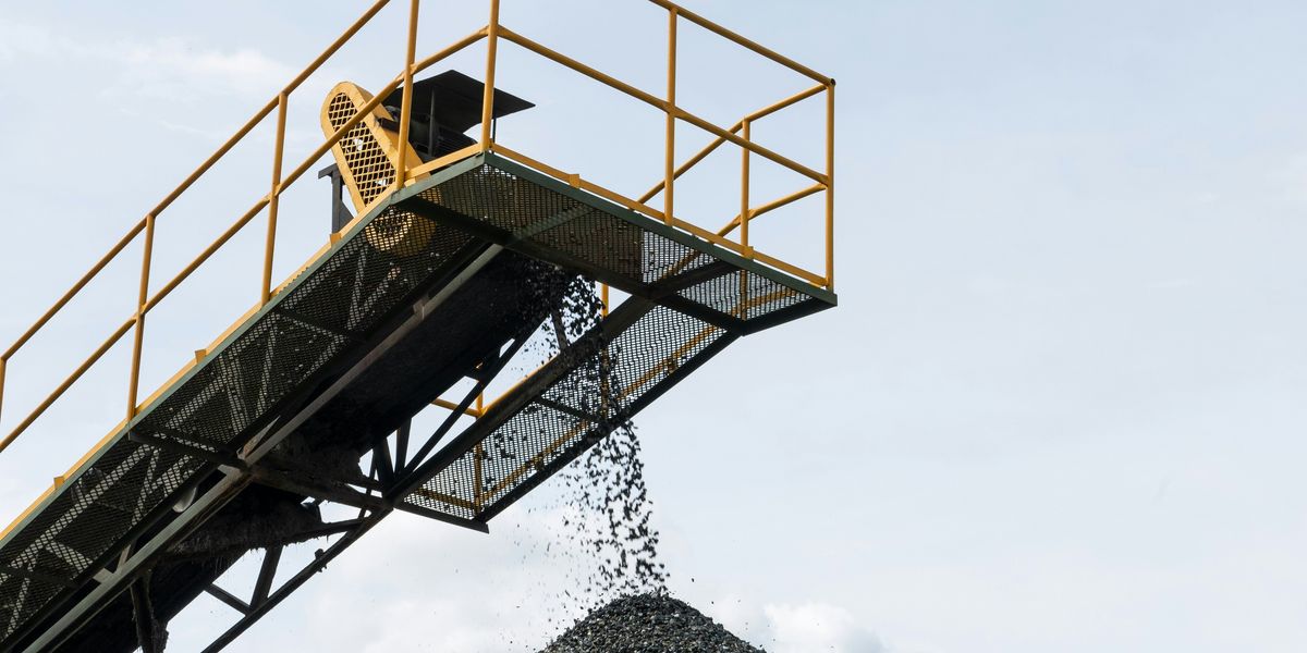 Coal being dropped onto a pile from a tall conveyer belt.