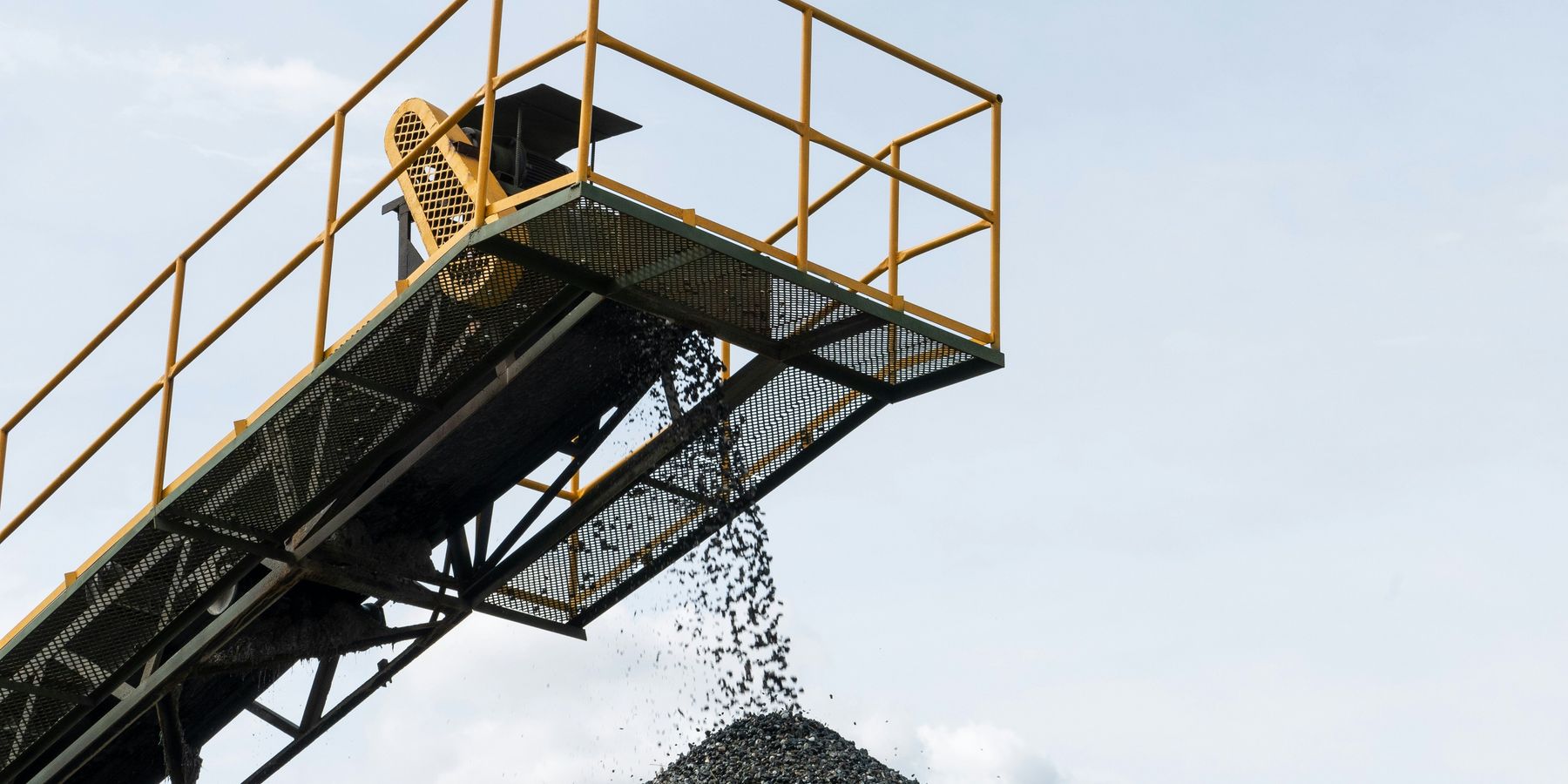 Coal being dropped onto a pile from a tall conveyer belt.