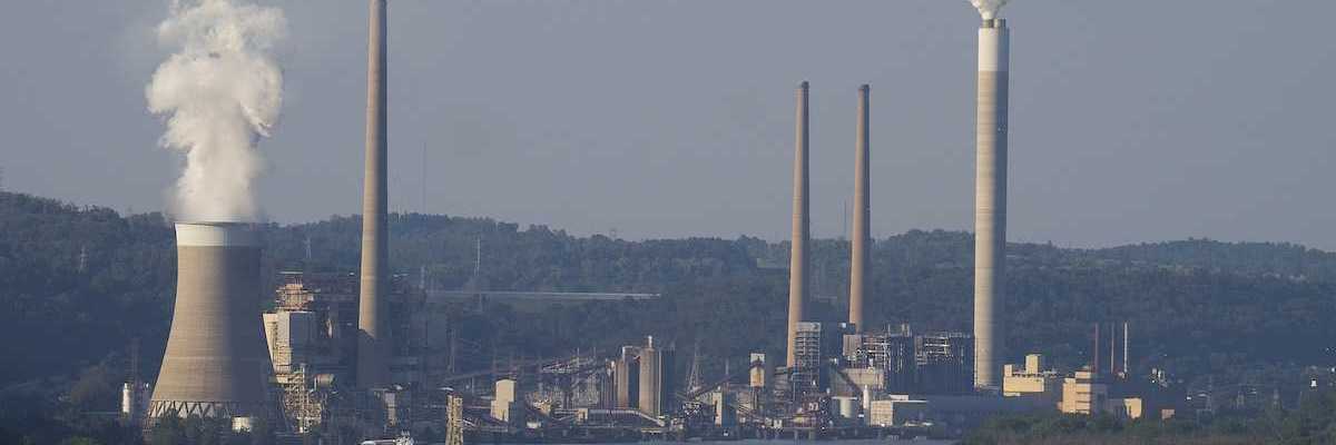 Coal fired electricity power plant along a river with a barge.