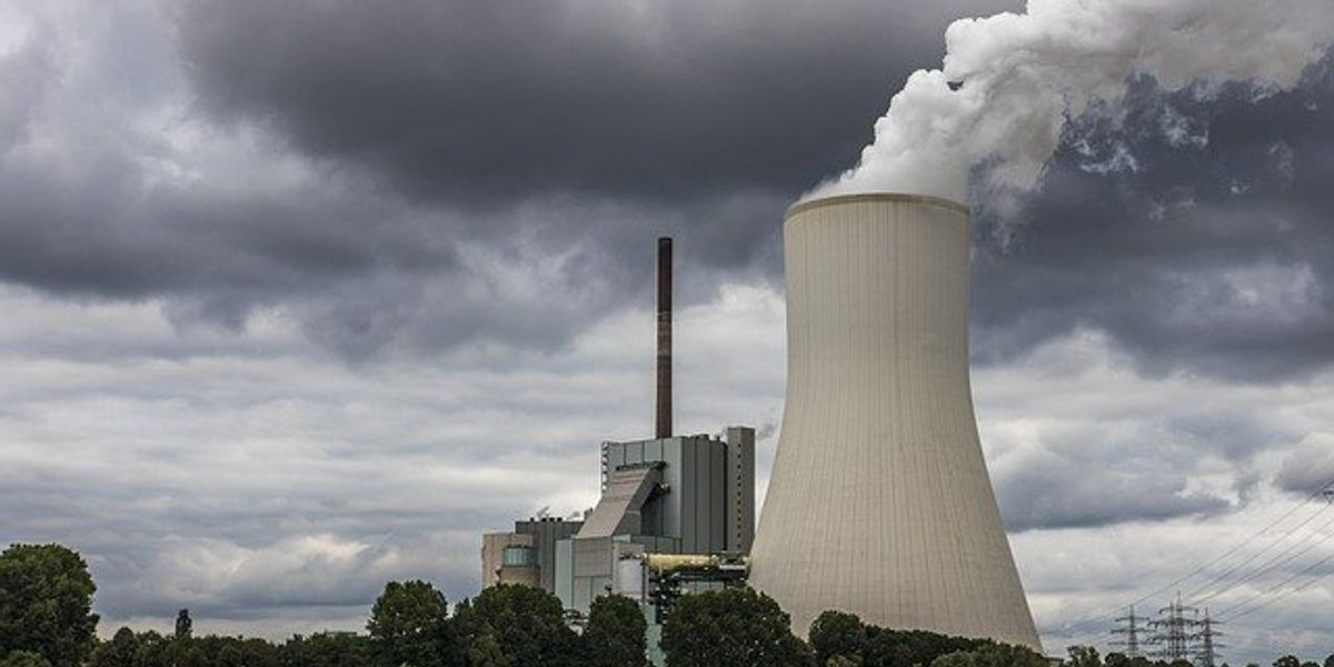 Coal plant with smoke billowing from a tower.