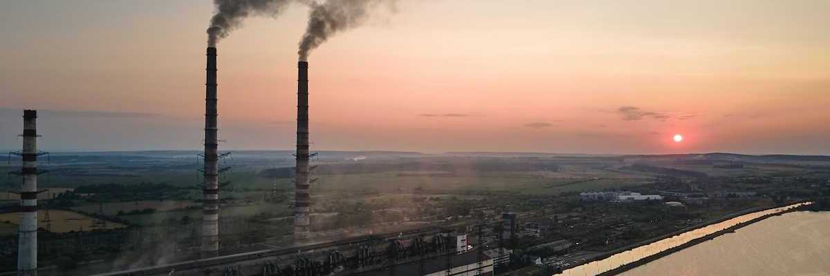Coal power as exemplified by twin smokestacks emitting pollutants