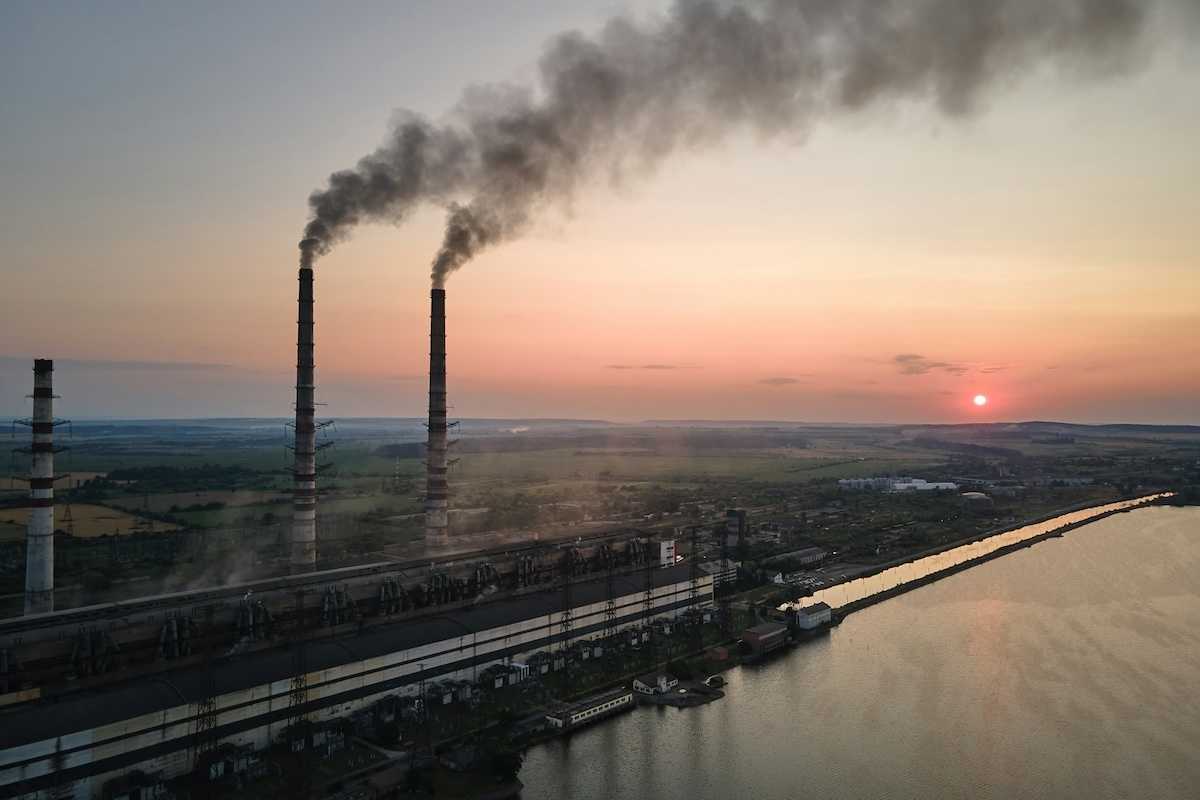 Coal power as exemplified by twin smokestacks emitting pollutants